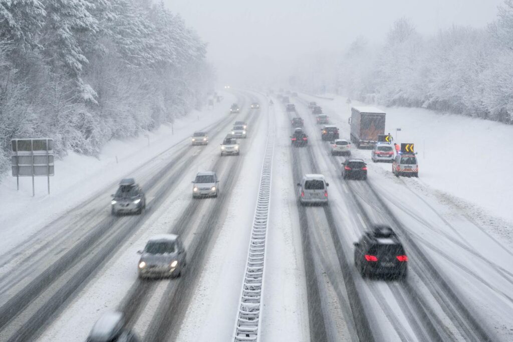 cars driving on highway in snowy conditions